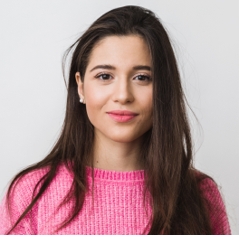 A girl with dark long hair in a pink pullover