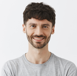 A young man with crossed arms in grey tshirt with confident look on his face