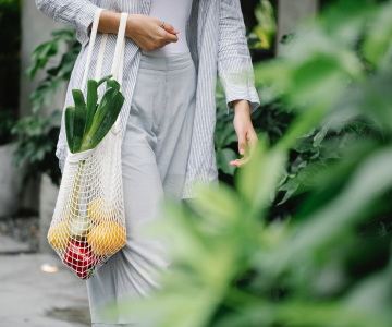 Lady with a net full of fresh vegetables